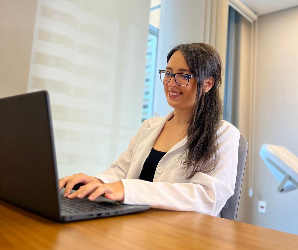 Nutricionista Hellen sorrindo no consultório